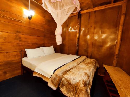 努沃勒埃利耶沐恩普莱斯森林小木屋的卧室配有木墙内的一张床