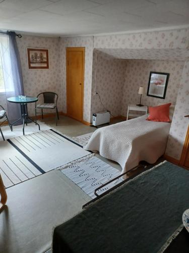 瓦尔德马什维克Kopparhyttan1的一间带大床的卧室和一间带桌子的房间