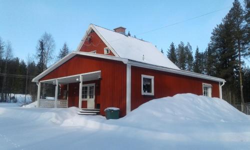 ÖverkalixVilla Polarktis的一座红谷仓,四周积雪成堆