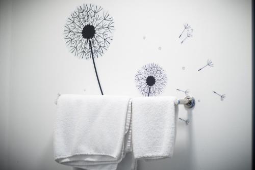 欧文The Dwelling Place的浴室墙上有一条毛巾和一朵花