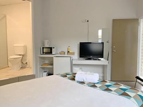 黄金海岸Aqua Blue Motel的客房设有1张床、1台电视和1间浴室。
