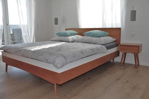 西普林根REBHAUS Ferienwohnung Weinlaube的卧室内的一张带两个枕头的床