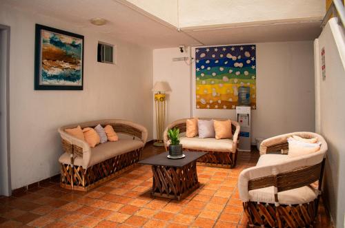 曼萨尼约Hotel Caracoles的客厅配有两把椅子和一张桌子