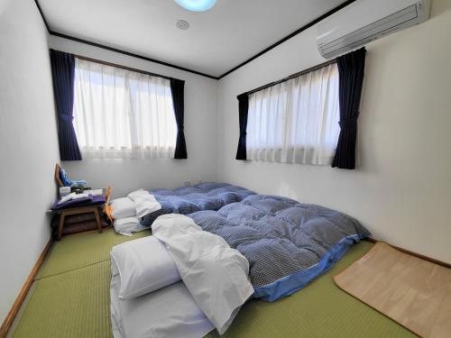 笛吹市铁之家铁道旅馆的一间带一张大床的卧室,位于带窗户的房间内