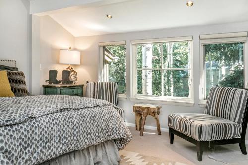 阿斯潘Villa's of Aspen by Snowmass Vacations的一间卧室配有一张床、两把椅子和窗户