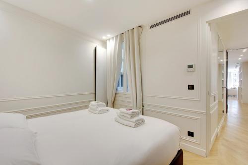 巴黎Stunning apartment with view at the very heart of Paris的白色卧室,配有带毛巾的床
