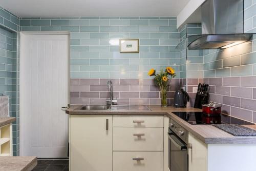 特鲁罗Truro apartment in a stunning quiet location的厨房配有水槽和花瓶