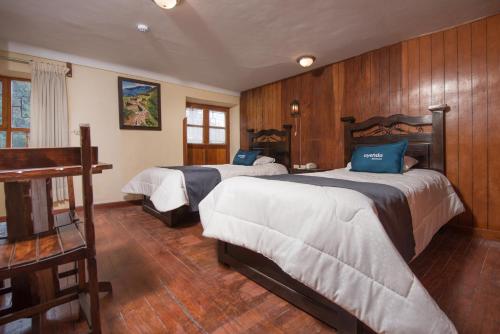 库斯科Ayenda Casa Escondida San Cristóbal Premium的木墙客房的两张床