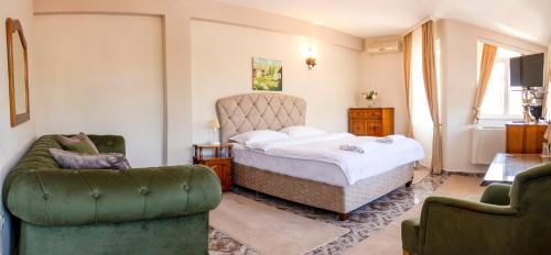 米内拉尔尼巴尼Family Hotel Victoria Gold的一间卧室配有一张床和两把椅子