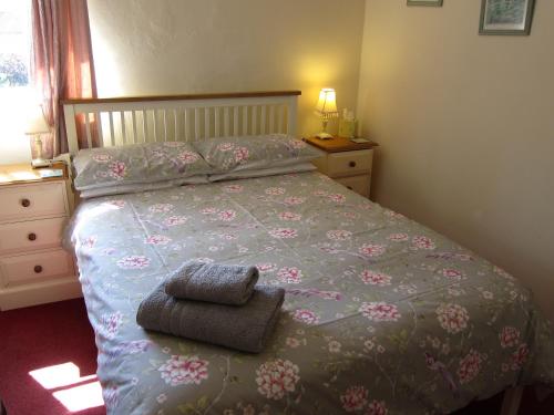 MartonBlack Swan Guest House的一间卧室配有一张带鲜花床罩的床