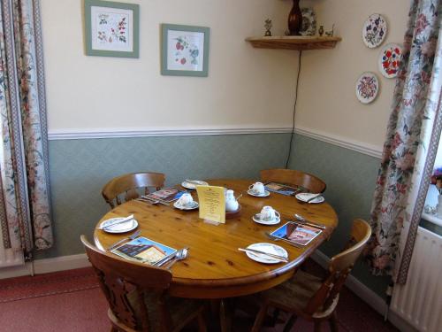 MartonBlack Swan Guest House的配有椅子和桌椅的木桌