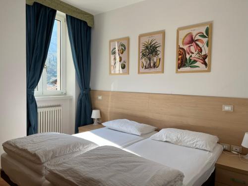 托尔博莱Appartamenti Baia Azzurra 5.的一间卧室设有两张床,墙上挂有绘画作品