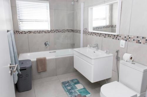 开普敦MLMK Property 17的一间带水槽、浴缸和卫生间的浴室