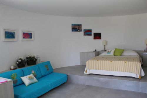 阿纳卡普里La Rotonda的一间卧室配有一张床和一张蓝色的沙发