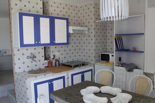 阿纳卡普里La Rotonda的一间小厨房,配有蓝色橱柜和一张桌子