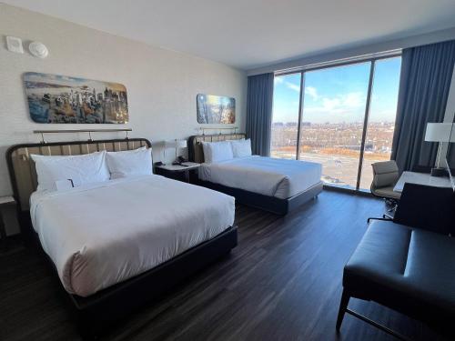 皇后区Hyatt Regency JFK Airport at Resorts World New York的酒店客房设有两张床和大窗户。