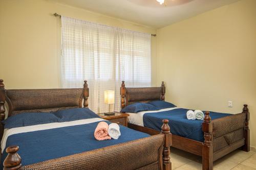 苏莎亚Amazing Condos at Sosua Ocean Village的卧室设有两张床,配有蓝色的床单和窗户。