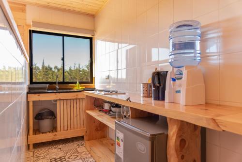 皮奇勒姆360 Lodge Pichilemu的厨房配有柜台、水槽和窗户