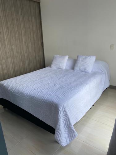 佩雷拉Apartasuite 01的一张带白色床单和枕头的床