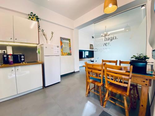 雅典Small Gem Studio Athens, next to metro nomismatokopeio的厨房配有桌椅和冰箱。