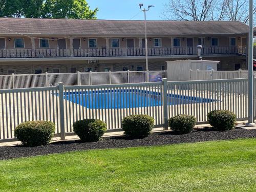 赫尔希White Rose Motel - Hershey的房屋前方设有游泳池的白色围栏
