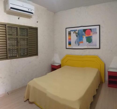 大坎普Flat & Residence Premium - Apês mobiliados e bem equipados的一间卧室设有黄色的床和窗户。