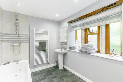 海伯敦桥Weavers Cottage的白色的浴室设有浴缸、水槽和卫生间。