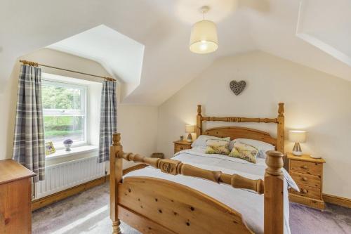 阿尼克Briar Cottage的一间卧室设有一张木床和一个窗户。