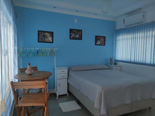 雅乌Lindo quarto c/ banheiro privativo的蓝色卧室,配有床和桌子