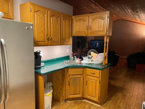 托伯莫里雪松维斯塔汽车旅馆的厨房配有木制橱柜和冰箱。