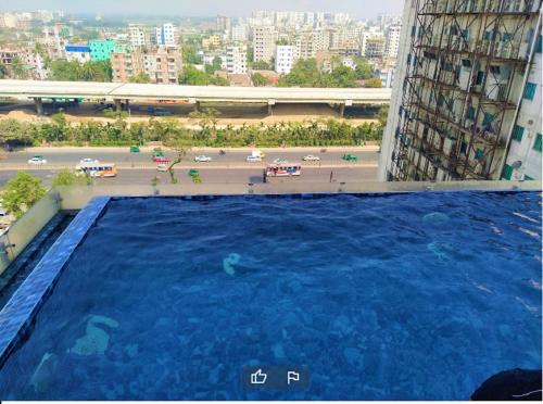 达卡Best Western PLUS Maya - Luxury Collection Hotel的大楼一侧的大型游泳池