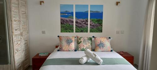 博瓦隆Harmony Self-Catering Apartments的卧室配有一张墙上有两张照片的床。
