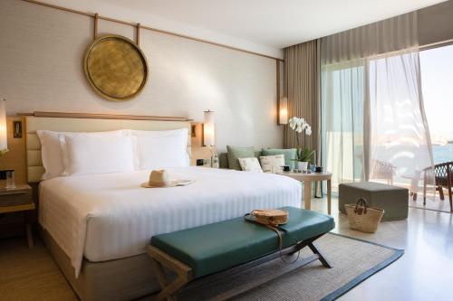 马斯喀特Jumeirah Muscat Bay的一间卧室设有一张大床和一个大窗户