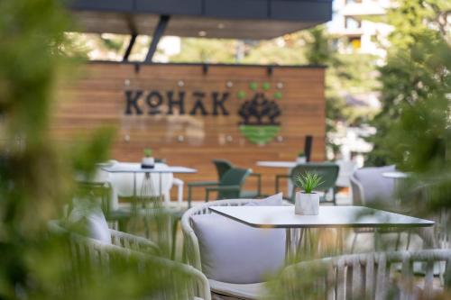 兹拉蒂博尔Konak Apartmani & SPA的一间设有桌椅的餐厅,并标有读克里蒂斯语的标志