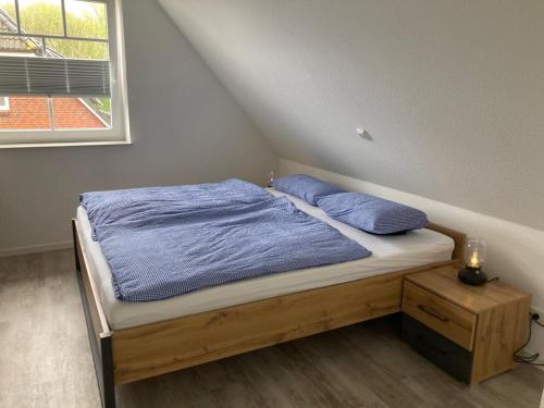 佩尔沃姆Traumfänger Urlaub direkt am Meer的一间卧室配有一张带蓝色床单的床和一扇窗户。