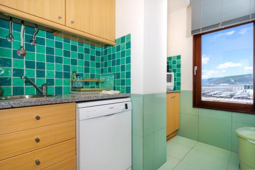特罗亚Big Fish Troia的绿色瓷砖厨房配有水槽和洗碗机