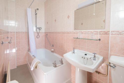 韦茅斯皇冠酒店的一间带水槽、浴缸和卫生间的浴室