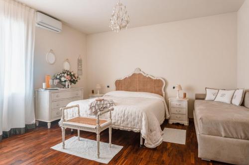 马尔米堡Villa Diletta b&b的一间卧室配有一张床、一把椅子和一个梳妆台