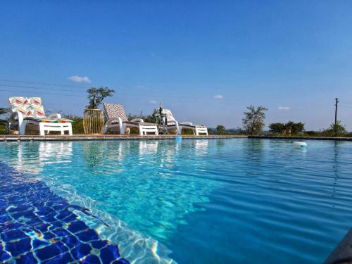 VendalandNandoni Waterfront Resort的一个带椅子和蓝色水的大型游泳池