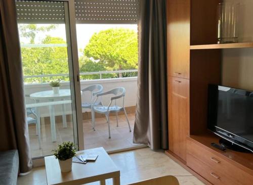 卡斯特尔德费尔斯马索尔公寓式酒店的带电视的客厅和带桌子的阳台。