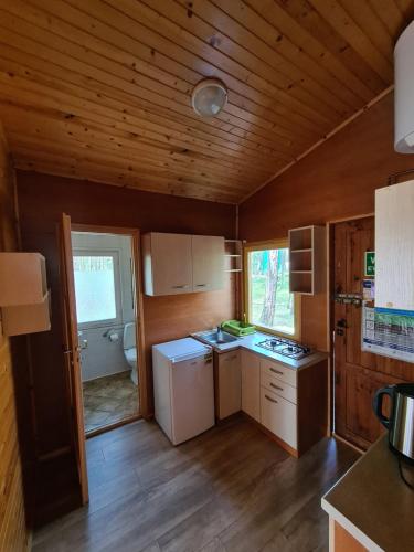 波别罗沃Leśna Przystań的一间厨房,配有白色家电和木制天花板