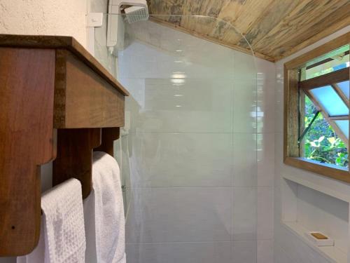 西波山Casa da Rê的一间带白色毛巾和窗户的浴室