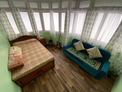大吉岭Basnet Apartment的一间卧室配有一张床、一张沙发和窗户。