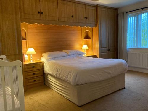 康多纳Springfield Holiday Home的一间卧室配有一张大床和木制床头板