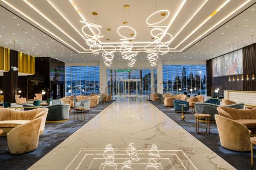 阿依纳帕Chrysomare Beach Hotel & Resort的大堂配有沙发、椅子和吊灯