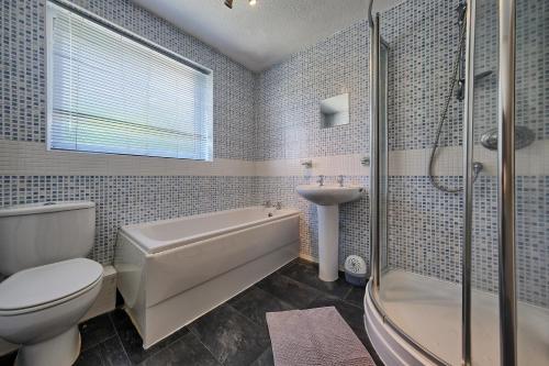 伯肯黑德Upton Village Guest House的浴室配有卫生间、浴缸和水槽。