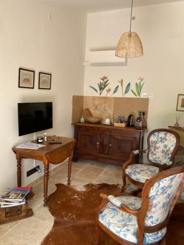 尼姆Guest House Encantada的客厅配有电视、椅子和桌子
