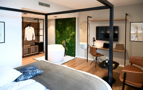 奥胡斯奥胡斯市奥西亚酒店的一间卧室配有一张床,另一间卧室配有书桌