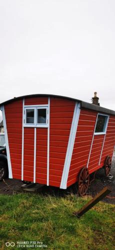 牛顿莫尔Gypsy hut的停在田野里的红色和白色拖车