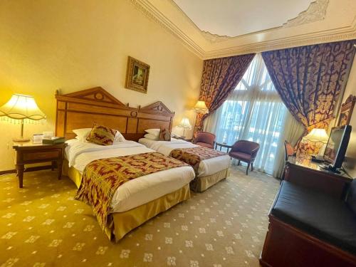 贝鲁特Serenada Golden Palace - Boutique Hotel的酒店客房设有两张床和电视。